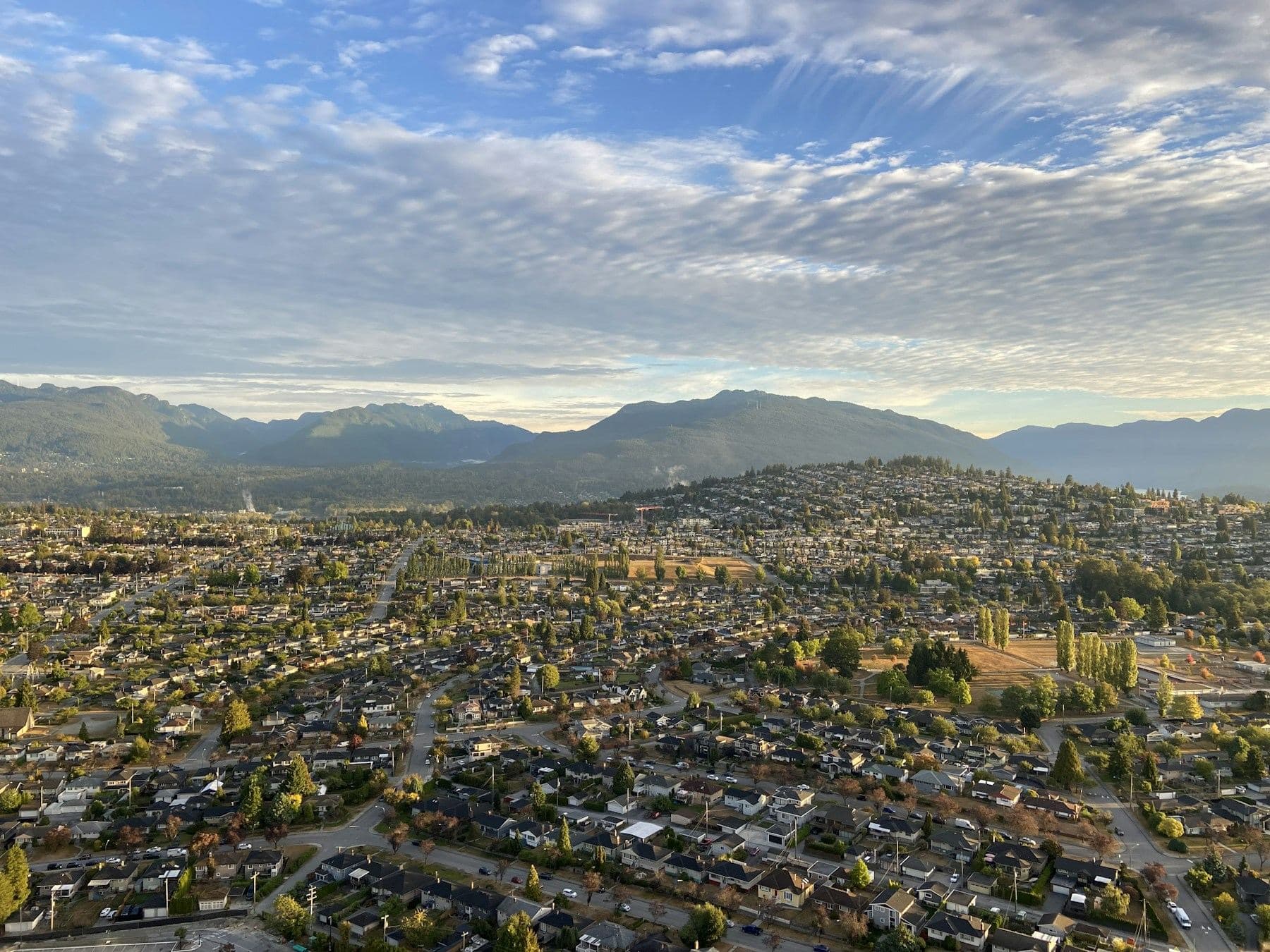 Aerial view over Brentwood, Burnaby toward the mountains